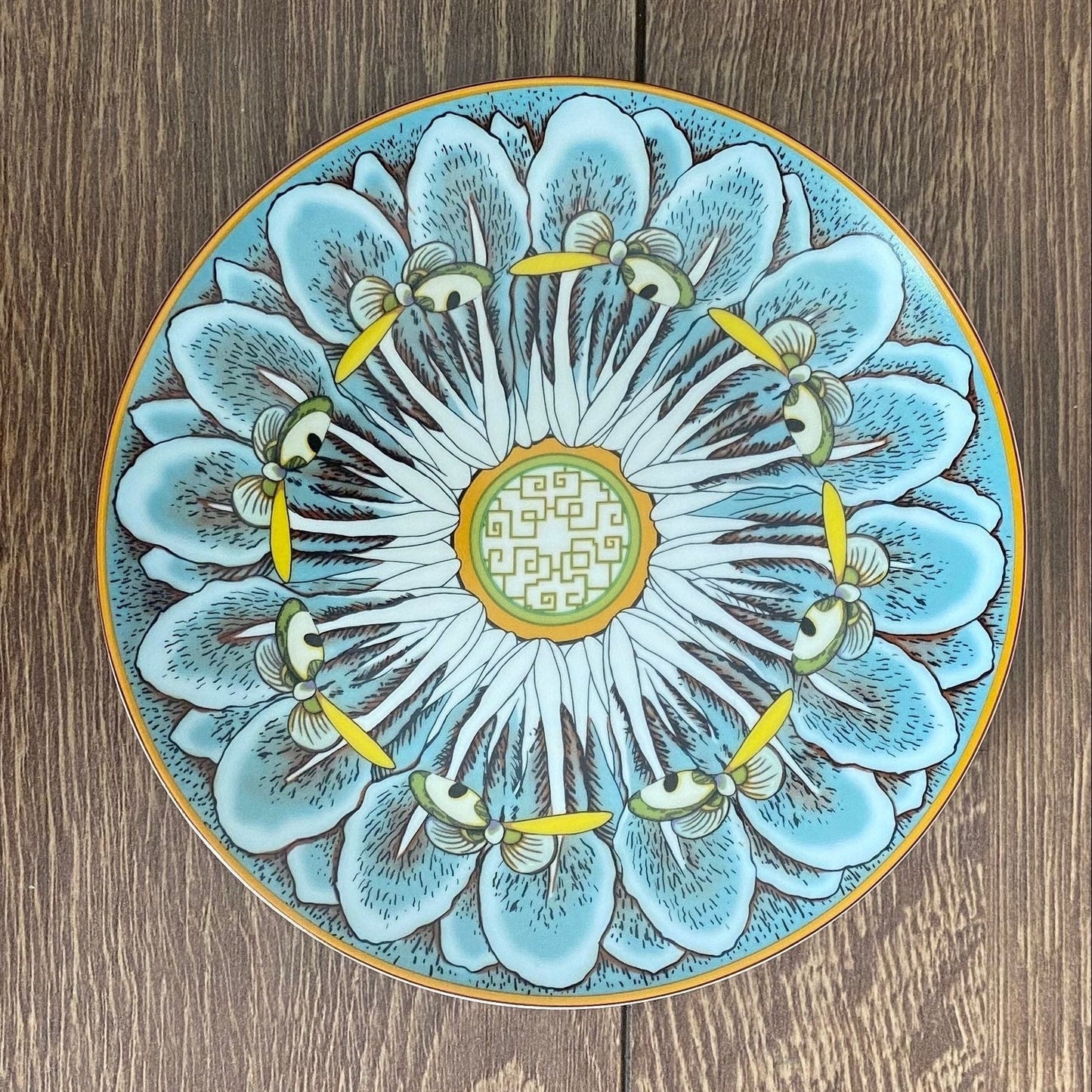 Decorative ceramic plate with floral design on a wooden surface