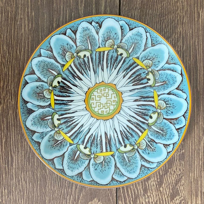 Decorative ceramic plate with floral design on a wooden surface