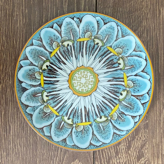 Decorative ceramic plate with floral design on a wooden surface